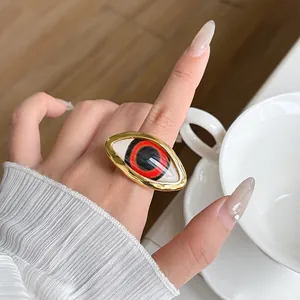 Close-up of a bold vintage gold-toned ring with a unique red and black evil eye motif