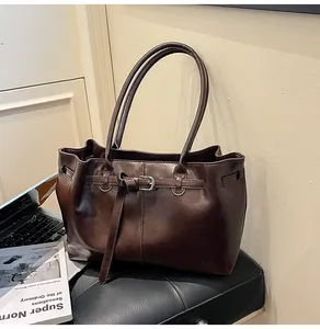 Detailed view of a large capacity dark brown faux leather tote bag in a casual setting