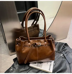 Close-up of a vintage brown leather tote bag featuring a stylish buckle and strap detail