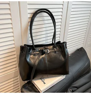 Detailed view of the sleek black faux leather texture and elegant buckle accent
