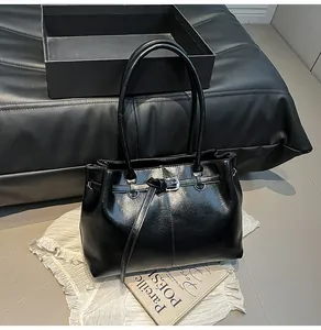 Elegant black faux leather shoulder bag with buckle detail and minimalist chic design style
