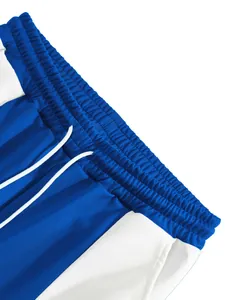 Detailed close-up of elastic waistband and drawstring on blue and white jogging pants.