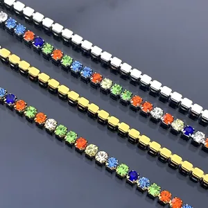 Close-up macro shot of 18K gold and silver titanium steel chains with colorful rhinestones