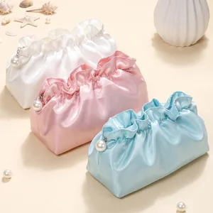 Three ruffled cloud-style cosmetic bags in satin silk, colors white, pink, and blue.
