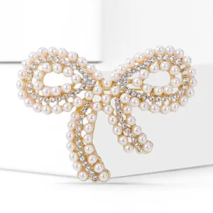 Élégante broche nœud dorée avec perles et strass pour costumes de mariage et vêtements.