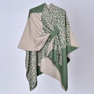 Vista dettagliata di un poncho in maglia leopardata verde con cinturino laterale