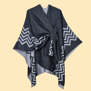 Dettaglio di uno scialle poncho caldo da donna con motivo a zigzag e chiusura laterale