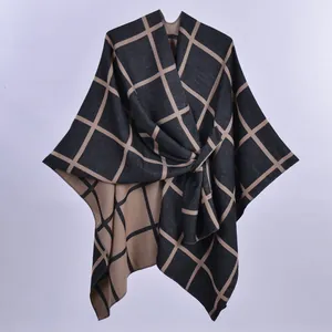 Dettaglio di un poncho scozzese da donna con elegante fiocco laterale e morbida maglia