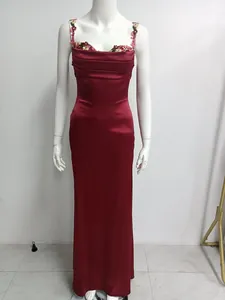 Gros plan d'une robe de soirée longue en satin bordeaux avec broderie florale chic
