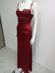 Vue détaillée d'une robe longue en satin bordeaux avec d'élégantes broderies florales