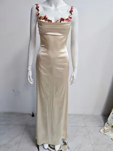 Détail d'une robe nuisette longue en satin champagne avec broderies fleurs