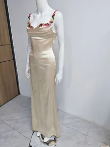 Robe longue en satin champagne avec broderie florale complexe sur les bretelles et le décolleté.