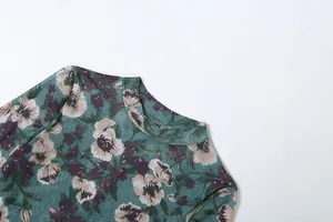 Detailopname van de elegante hoge halslijn en bloemenprint van de jurk.