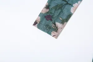 Gedetailleerde weergave van de mouwmanchet van een vintage groene bloemenjurk met print