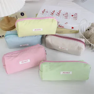 Multi-colored macaron pastel pencil cases arranged on a desk with cute props.