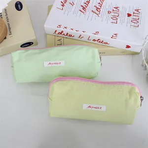 Close-up of two pastel macaron-colored minimalist pencil cases with pink zippers.