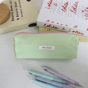 Close-up detail of a pastel green macaron pencil case with Mayrabbit woven label