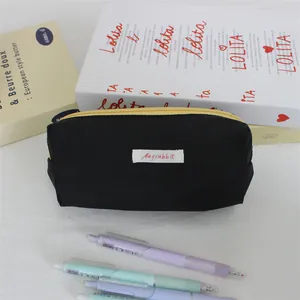 Close-up of minimalist black ins style pencil case with colorful pens in foreground