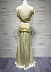 Detaillierte Rückansicht eines eleganten gelben Satin-Zweiteilers mit gerafftem Rock-Design