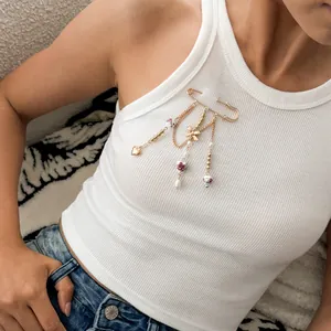 Vintage heart alloy brooch with bow beads on white ribbed tank top lifestyle shot