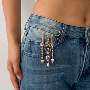 Detailed view of dopamine heart alloy brooch with sweet bow and CCB beads on denim