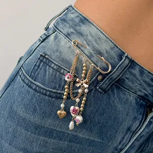 Detailed view of an INS-style heart beaded brooch pinned on denim pocket