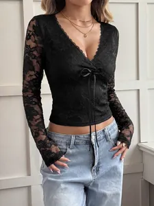 Elegante top in pizzo nero con scollo a V e dettaglio fiocco sul davanti.