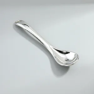 Macro view of a silver-tone vintage alloy spoon pendant accessory for DIY jewelry making