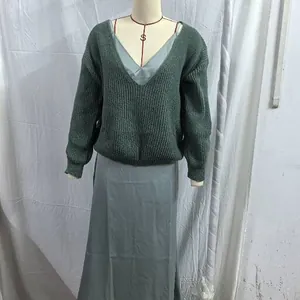 Dark green oversized knit sweater paired with a light blue satin slip dress on a mannequin