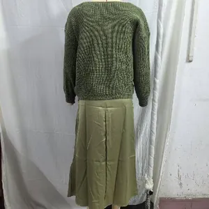 Back view of women's two-piece set featuring olive knit sweater and satin midi dress