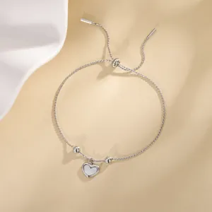 Detailed macro shot of an adjustable silver bracelet with a heart-shaped shell charm