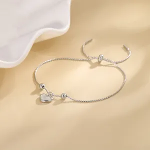 Close-up of elegant silver heart shell bracelet with adjustable drawstring design