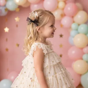Close-up of a sparkling gold princess crown hair clip worn by a girl at a birthday party.