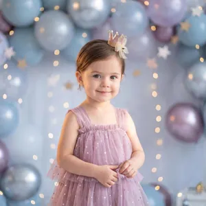 Adorable toddler girl wearing a pink mesh crown hair clip for a birthday party setup
