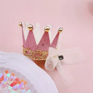 Detailed close-up of a pink glitter crown hair clip with a lace bow and gold trim.