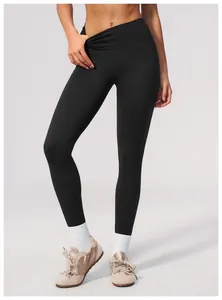 Professional close-up of black seamless high-waisted yoga pants on a fitness model in studio.
