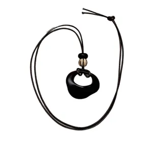 Collana lunga in stile cinese minimalista con ciondolo organico nero e cordino marrone