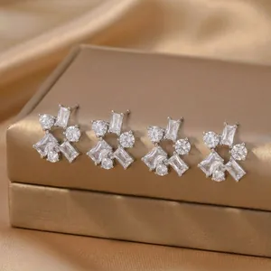 Close-up of elegant silver geometric stud earrings with clear baguette and round zircons