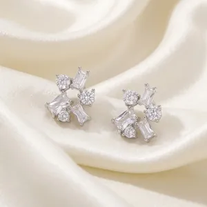 Detailed view of geometric silver earrings featuring round and baguette cubic zirconia