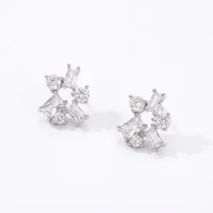 Close-up of geometric stud earrings featuring shimmering white cubic zirconia stones.