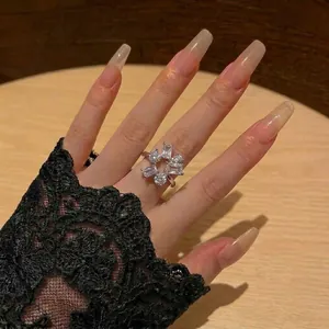Close-up view of an elegant silver flower ring with sparkling cubic zirconia stones on hand