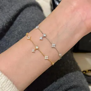Detailansicht von zwei zarten Gold- und Silberarmbändern mit Zirkonia am Handgelenk