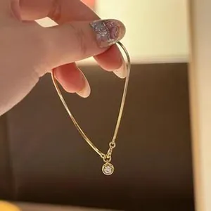 Detaillierte Nahaufnahme einer goldfarbenen Kette mit rundem Zirkonia-Anhänger