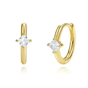 Nahaufnahme eleganter goldener Creolen mit einem brillant quadratisch geschliffenen Zirkon
