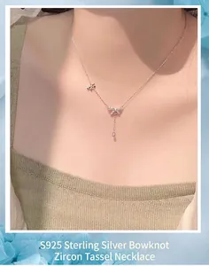Close-up of S925 silver necklace with zircon bow and tassel worn by model