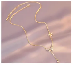 Elegant gold bow necklace with sparkling zircon pavé and delicate tassel detail.