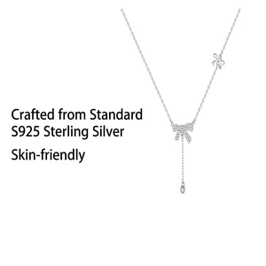 Close-up detail of S925 sterling silver bow necklace with elegant zircon tassel