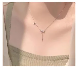 Detailed macro view of S925 silver bow necklace with zircon tassel on model neck