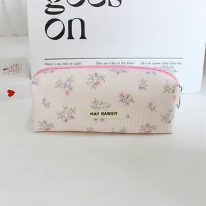 Detail view of a vintage floral print corduroy pencil case with a zipper closure