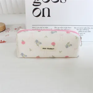 Macro detail view of a retro floral corduroy pencil case with MAY RABBIT brand label.